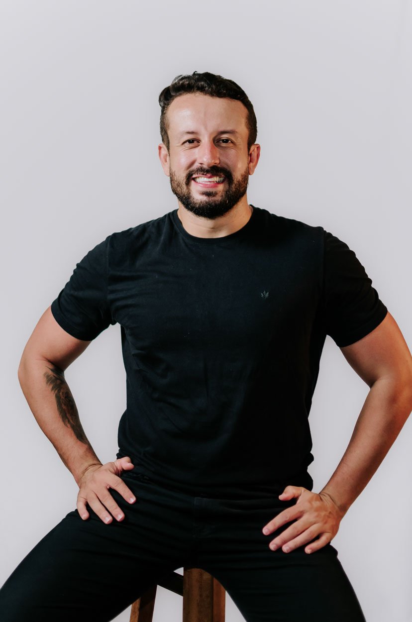 Prof. Lucas Gomes sentado, sorrindo
